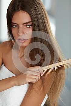 Brushing Hair. Woman Hairbrushing Beautiful Long Hair With Comb