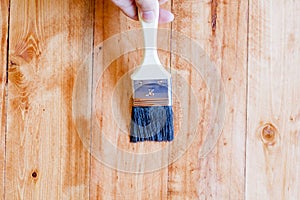 Brushing to apply varnish paint on a wooden surface