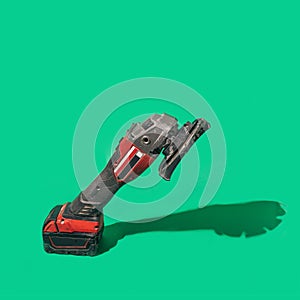 A brushless cordless Angle Grinder on beautiful green background with sunny shadow