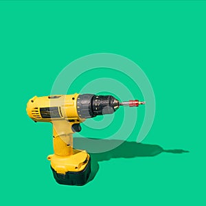 A brushless cordless Combi Drill on beautiful green background with sunny shadow