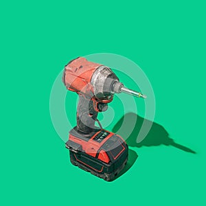 A brushless cordless impact driver on beautiful green background with sunny shadow