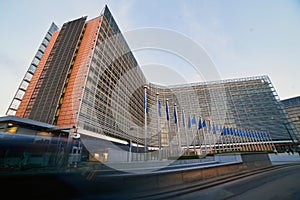 European Union EU flags waving in front of the Berlaymont building, headquarters of the European Commission in Brussels.