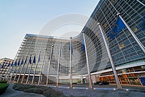 European Union EU flags waving in front of the Berlaymont building, headquarters of the European Commission in Brussels.