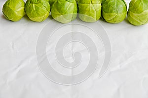 Brussels sprouts green vegetables on light table background. Flat lay close up top view copyspace design. Health food lifestyle