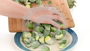 Brussels sprouts. Woman puts Brussels sprouts off cutting board on a plate