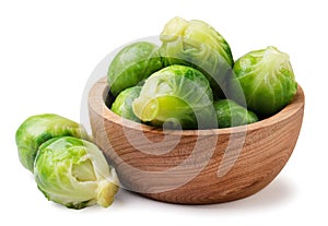 Brussels sprouts in a wooden plate on a white background.Isolated