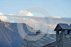 Typical roof and chimney with views of the Brusson mountains, Aosta Valley, Italy. photo