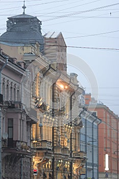 Brutal architecture with columns, stucco and rhythm of windows and lamp posts in foggy day.