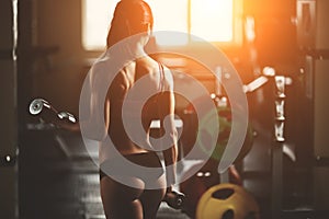 Brutal athletic woman pumping up muscles with