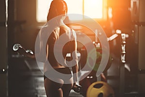 Brutal athletic woman pumping up muscles with photo