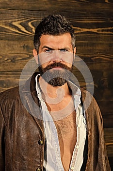 Brutal attractive man. Barber and hairdresser salon. Barber man with stylish hipster beard on wooden background