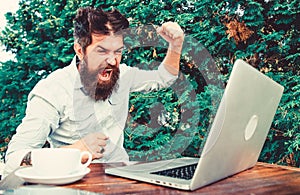 Brutal bearded hipster need coffee break. stressed man working on laptop. Frustrated office worker. aggressive