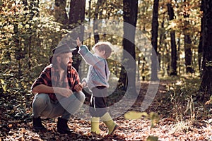 Brutal bearded man and little boy enjoy autumn nature. Family leisure. Family values. Explore nature. Wanderlust concept