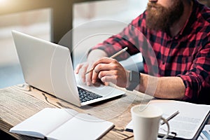 Brutal bearded man sitting at the table