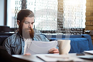 Brutal bearded man sitting at the table