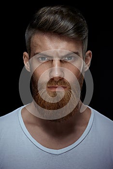 Brutal bearded man in a white T-shirt