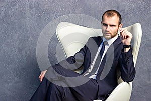 Brutal businessmen in suit with tie sitting on chair