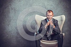 Brutal businessmen in suit with tie sitting on chair