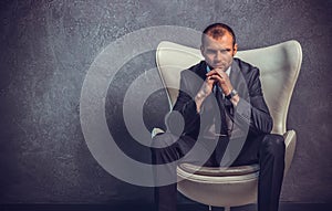 Brutal businessmen in suit with tie sitting on chair