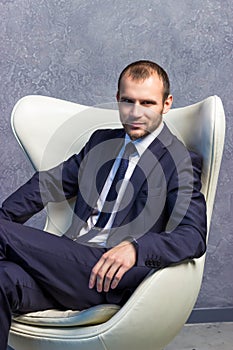 Brutal businessmen in suit with tie sitting on chair