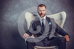 Brutal businessmen in suit with tie sitting on chair