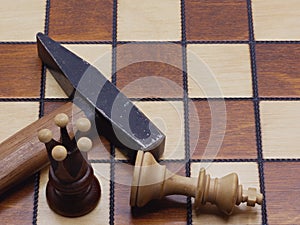 Brutal Checkmate: A Hammer Lying Next To A Defeated King On A Chess Board
