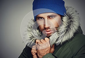 Brutal face a man with beard bristles and hooded winter