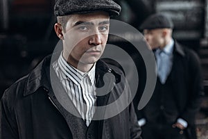 brutal gangsters posing on background of railway carriage. england in 1920s theme. fashionable confident man. atmospheric moments