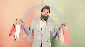 Brutal hipster shopper. big sale. male shopaholic hold shopping bags. present packages for holiday preparation. special