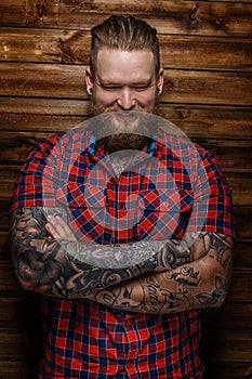 Brutal huge male with beard and tattooes with smile on his face