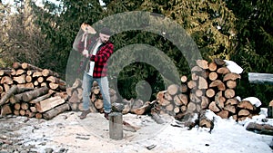 Brutal lumberjack chopping wood in the winter forest