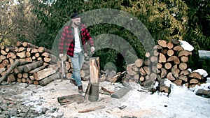 Brutal lumberjack chopping wood in the winter forest