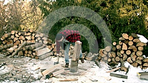 Brutal lumberjack chopping wood in the winter forest