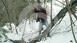 Brutal lumberjack chopping wood in the winter forest