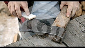 Brutal lumberjack neatly sharpens a blunt ax