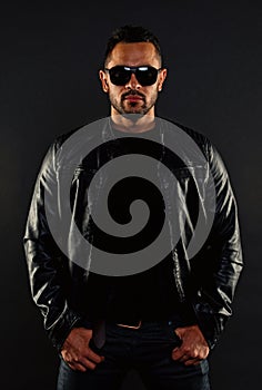 Brutal macho in leather jacket. Bearded man in fashion sunglasses. Mens sexuality and attraction. Fashion model in