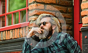 Brutal male with blond hair irish architecture background. Man casual fashion. Cool guy. Bearded man checkered shirt