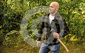 Brutal male in forest. Power and strength. Lumberjack carry ax. Bald woodsman. Harvest firewood. Hike vacation. Hike in