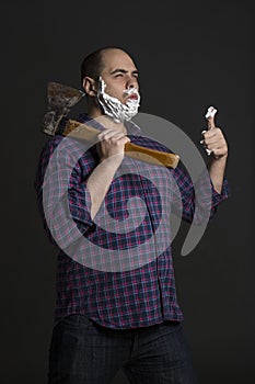 Brutal man with an ax in the hands and foam on his face