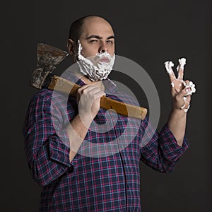 Brutal man with an ax in the hands and foam on his face