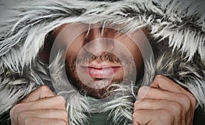 Brutal man with beard bristles and hooded winter photo