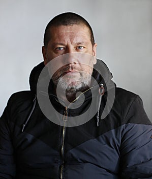 Brutal man with a gray beard in a jacket clous-up photo