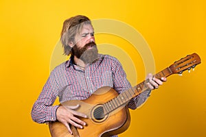 Brutal man. guy with beard and moustache play guitar. bearded man in checkered shirt sing song. music performer musician