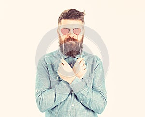 Brutal man in love. Blind from love. Hipster with paper red hearts and serious face. Bearded man holds symbols of
