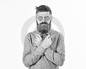 Brutal man in love. Blind from love. Hipster with paper red hearts and serious face. Bearded man holds symbols of