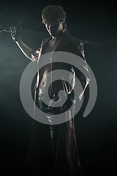 Brutal man with a sword isolated on black photo