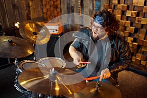 Brutal musician behind the drum kit on stage