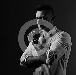 Brutal serious business man thinking in white style shirt on grey dark shadow background. Closeup portrait. Black and white