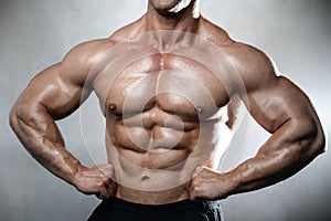 Brutal strong bodybuilder old man posing in studio grey background