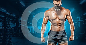 Brutal strong muscular bodybuilder athletic man pumping up muscles on gym background. Workout bodybuilding concept. Copy